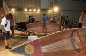 A large group of people working on several canoes